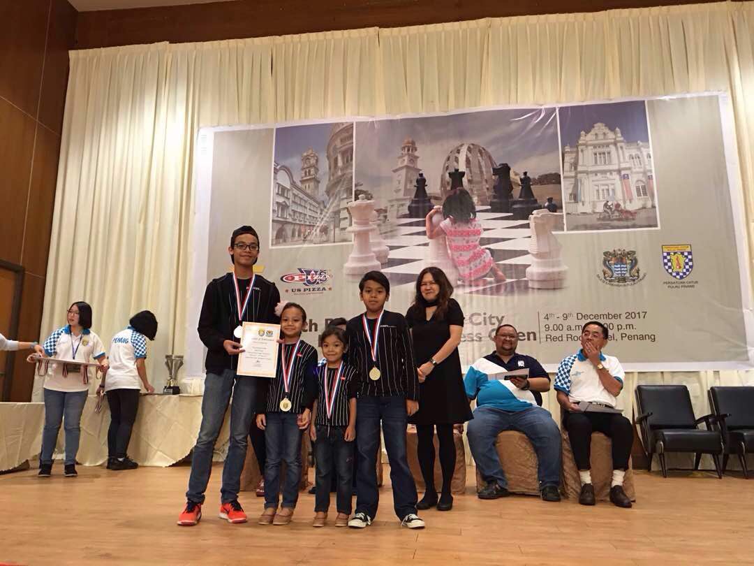 Four-year and six months old Ain Safiya with the rest of Team AAAA, accepting the prize of Best Family Team at the Chess League Team Tournament (Photo by Penang Chess Association)
