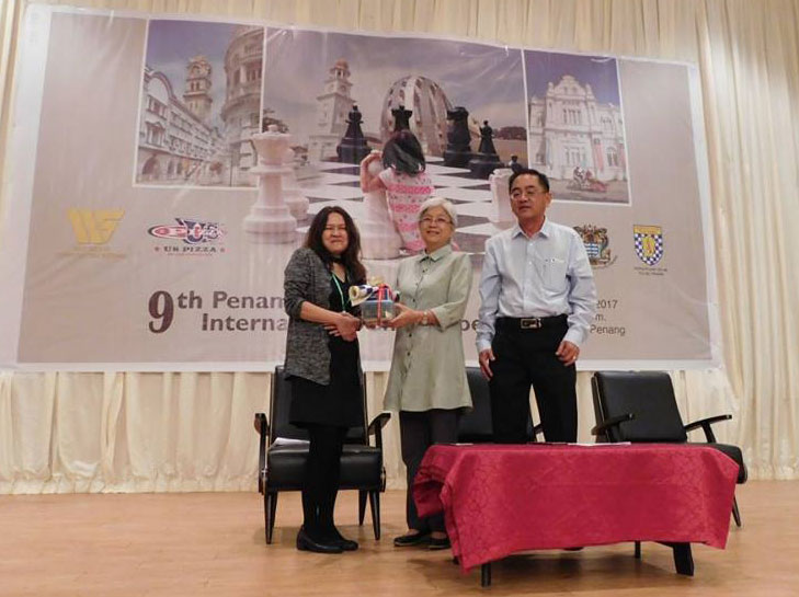 President of Penang Chess Association, Madam See Swee Sie (left) presenting a token of appreciation to Y.B. Chong Eng (centre). Looking on is the immediate past President of Penang Chess Association, Mr. Lee Ewe Gee (Photo by Penang Chess Association)