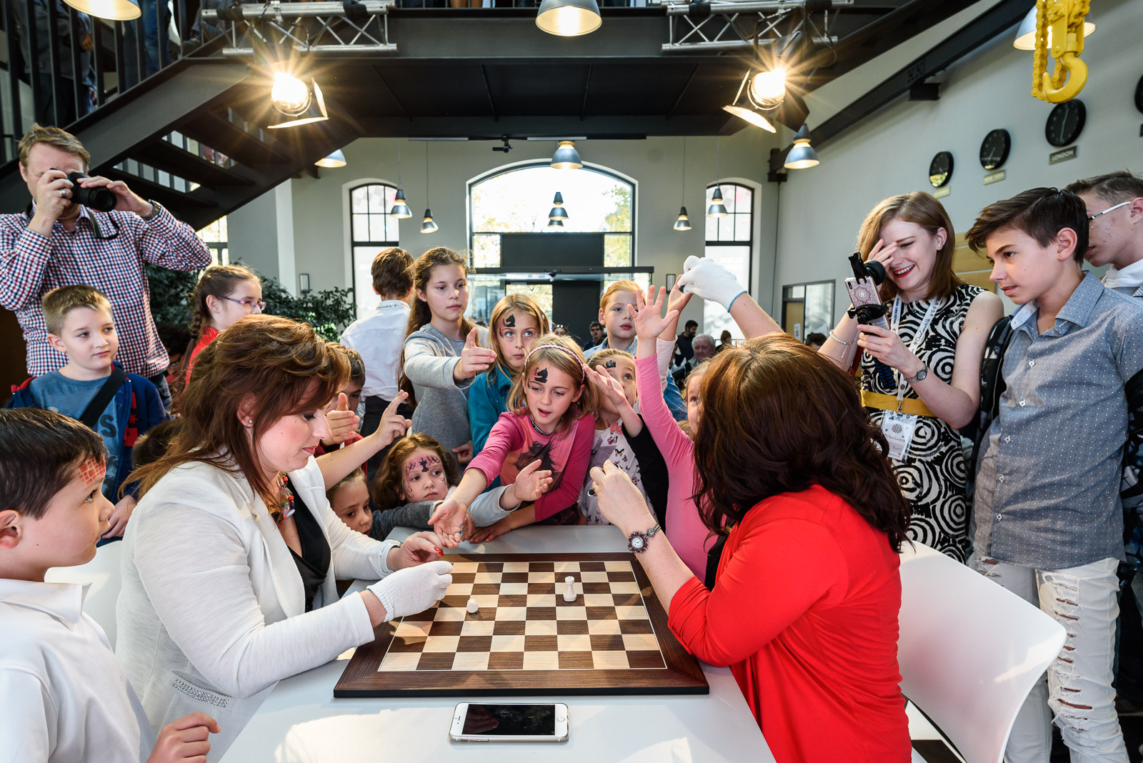 Judit and Sofia give away marzipan chess pieces to children