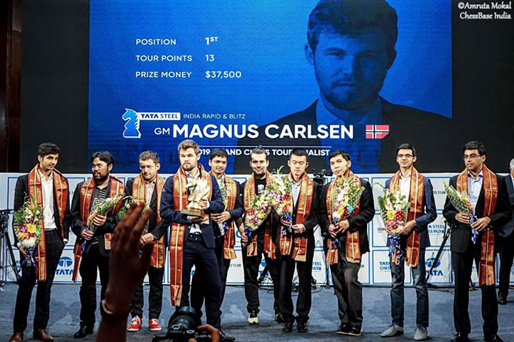 Magnus Carlsen at Tata Steel Chess 2019, Anish Giri walking…